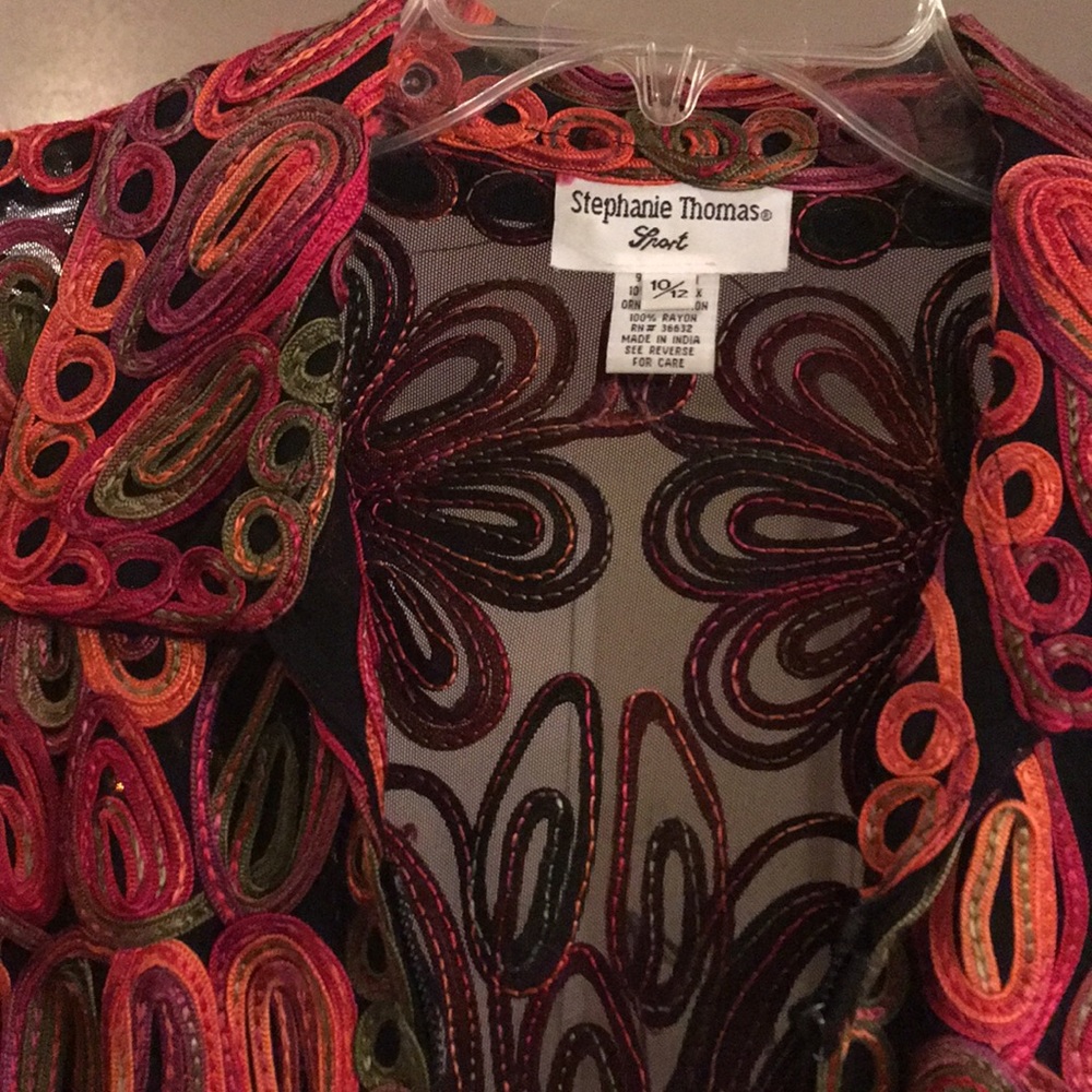 Intricate floral designs on black mesh jacket